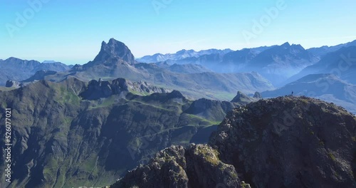 Aerial view of Anayet mountain range peak with man stangin on top  in Spanish and french Pyrenees in Summer morning