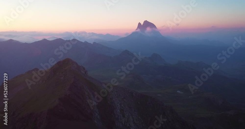 Aerial drone dolly footage Midi D ossau mountain peak in French  Pyrenees during sunset with orange light and glow photo