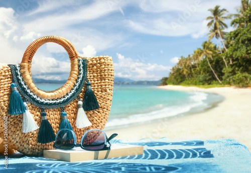 Fototapeta Naklejka Na Ścianę i Meble -  Tropical beach summer holiday accessories, with blurred beach palm trees and sea in background.