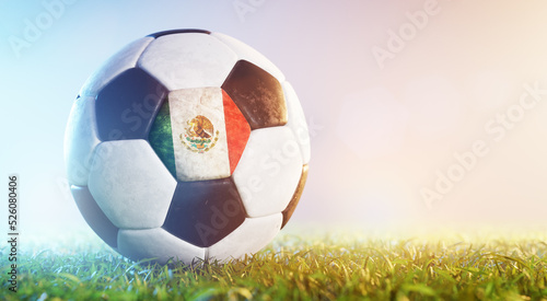 Football soccer ball with flag of Mexico on grass