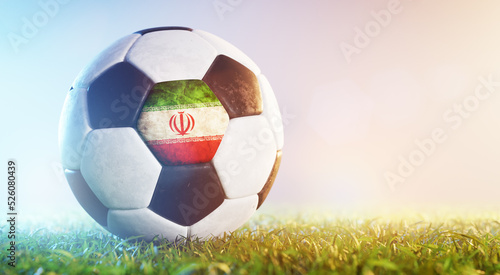 Football soccer ball with flag of Iran on grass