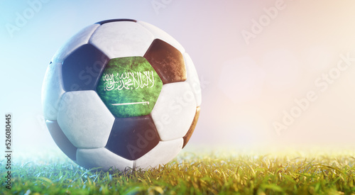 Football soccer ball with flag of Saudi Arabia on grass