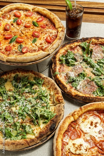 Vertical shot of a plate of different pizzas with coke