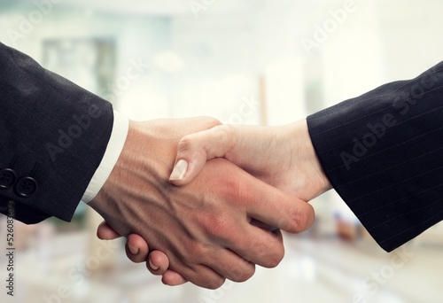 Business partnership. Male entrepreneurs shaking hands, celebrating cooperation agreement at office. Two happy businessmen handshaking after successful deal at modern company