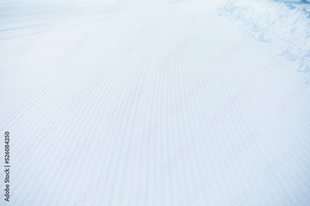 Snow lines made from a snow machine on a ski slope. Ski slope texture. Snow velvet. Selective focus. Snow lines made from a snow machine on a ski slope. Ski slope texture. Snow velvet. Selective focus.