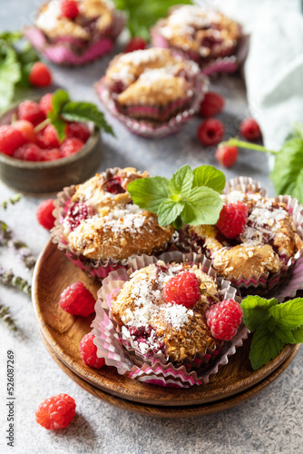 Healthy dessert. Vegan gluten-free pastry. Oatmeal banana muffins with raspberry and coconut flakes on a stone table.