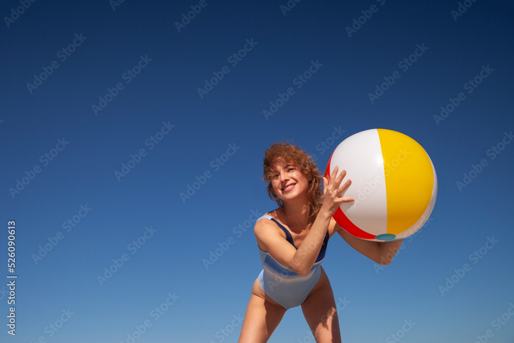 young woman in swimsuit with beach ball