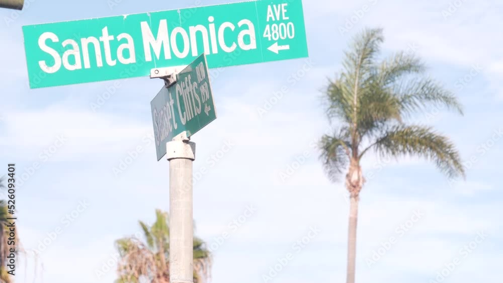 Santa Monica road sign on crossroad, California city street, USA. Waterfront tourist resort near Los Angeles, beachfront travel destination for waterside summer vacations. Coastal palm trees. Santa Monica road sign on crossroad, California city street, USA. Waterfront tourist resort near Los Angeles, beachfront travel destination for waterside summer vacations. Coastal palm trees.