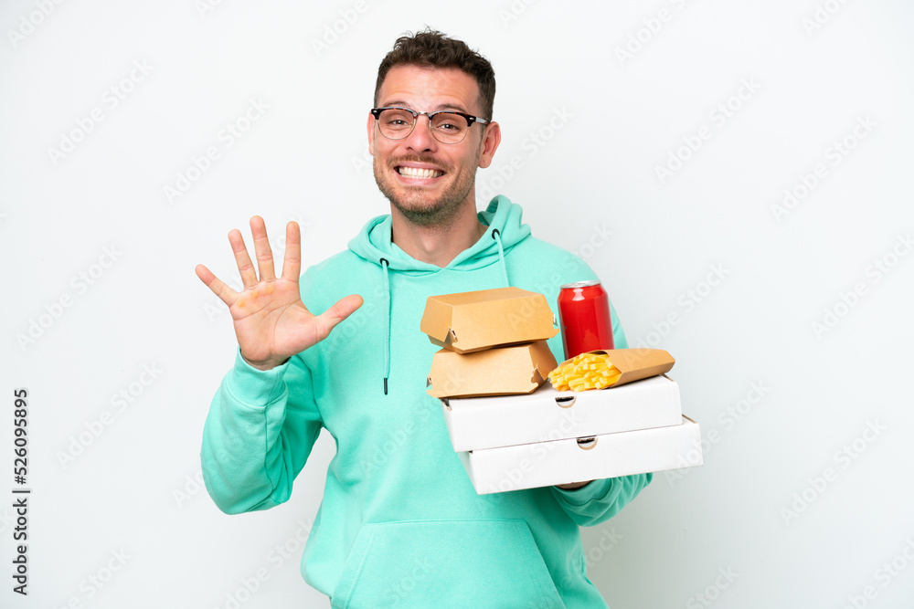 Young caucasian man holding fast food isolated on white background counting five with fingers Young caucasian man holding fast food isolated on white background counting five with fingers