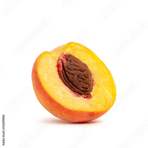 Half of a peach with a stone on a white background