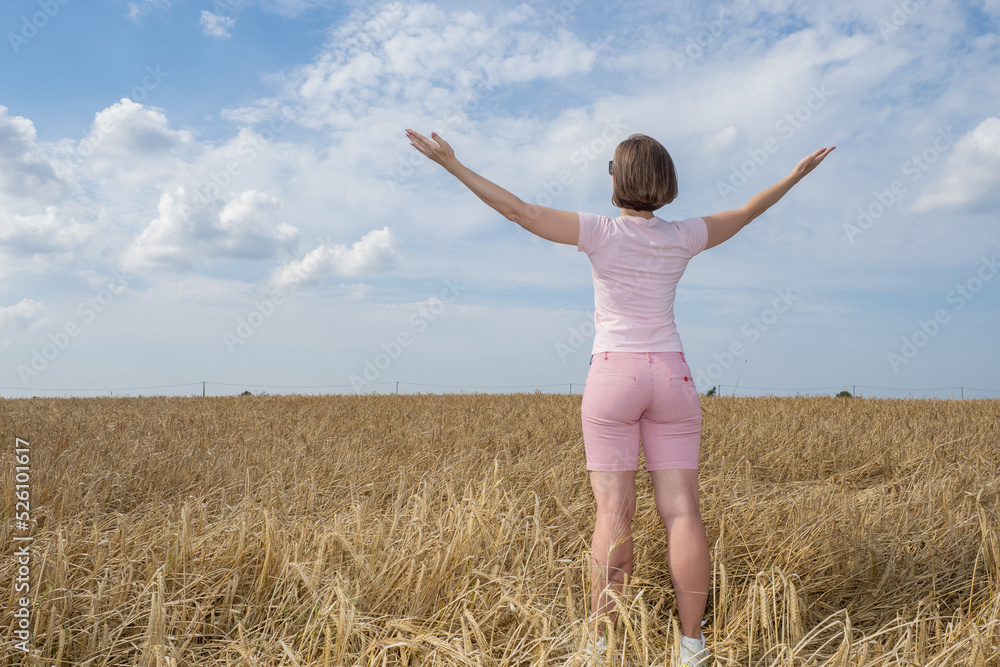 Manager of agricultural company. Woman in wheat field with her back to camera. Growing wheat and grain. Manager examines field with wheat. Employee of agricultural company rejoices at good harvest. Manager of agricultural company. Woman in wheat field with her back to camera. Growing wheat and grain. Manager examines field with wheat. Employee of agricultural company rejoices at good harvest.