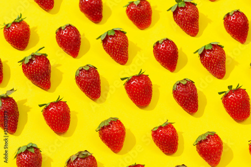 Fresh red strawberry isolated on yellow background, top view. Minimalistic strawberry pattern. Flat lay, copy space