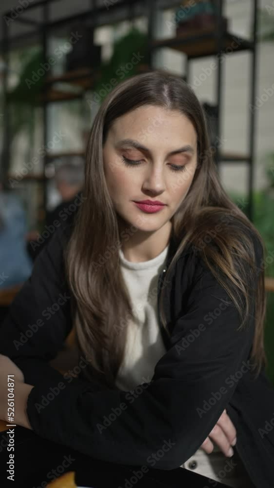 Portrait of a pensive thoughtful young woman at coffee shop. Meditative girl in 20s daydreaming looking outside window at cafe place Vertical video Portrait of a pensive thoughtful young woman at coffee shop. Meditative girl in 20s daydreaming looking outside window at cafe place Vertical video