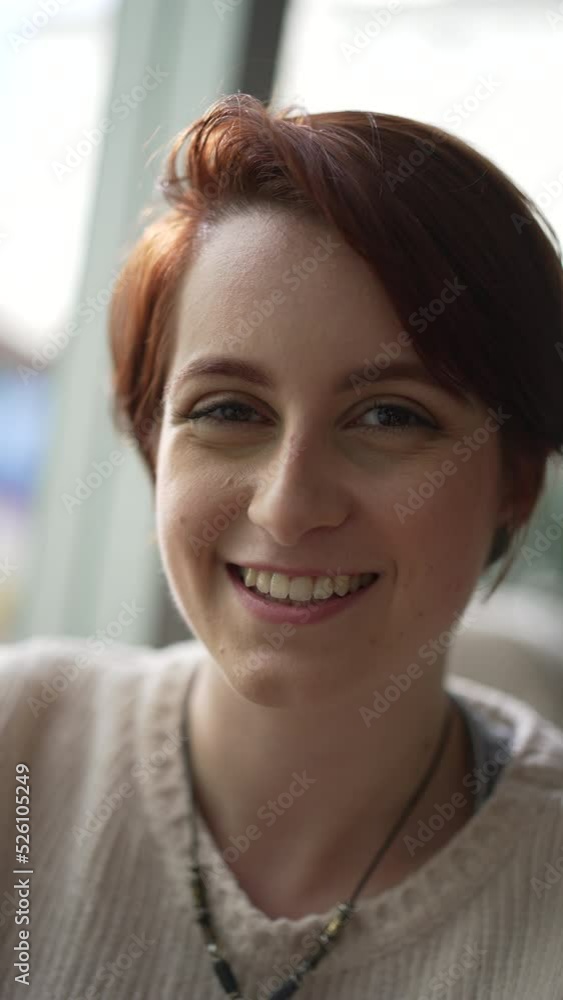 Portrait of a young red hair woman smiling at camera in vertical video. Happy 20 girl face Portrait of a young red hair woman smiling at camera in vertical video. Happy 20 girl face