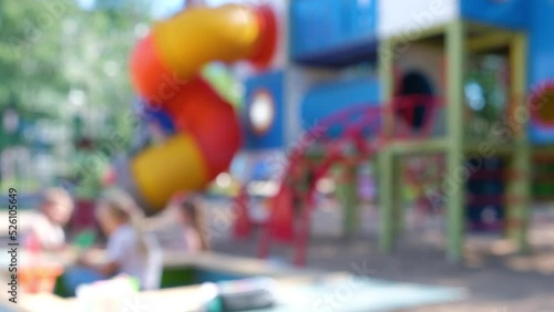 abstract background in blur, playground with children running and playing, play area without focus, sunny summer day