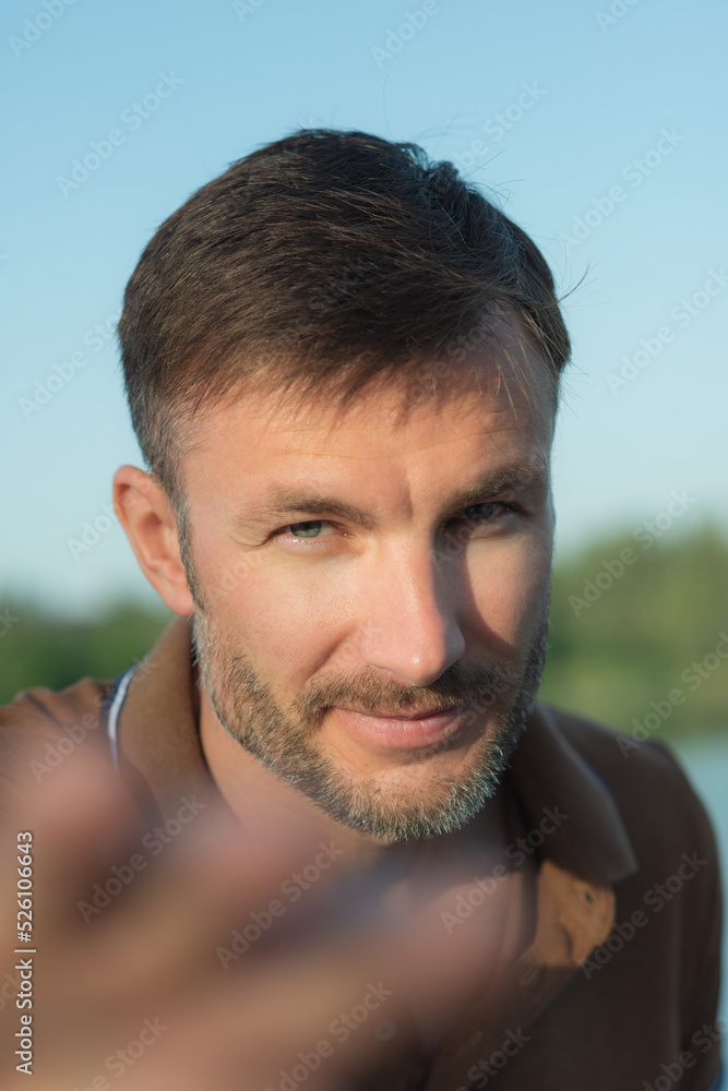One man with a beard smiles and looks at the camera, close-up. One man with a beard smiles and looks at the camera, close-up.