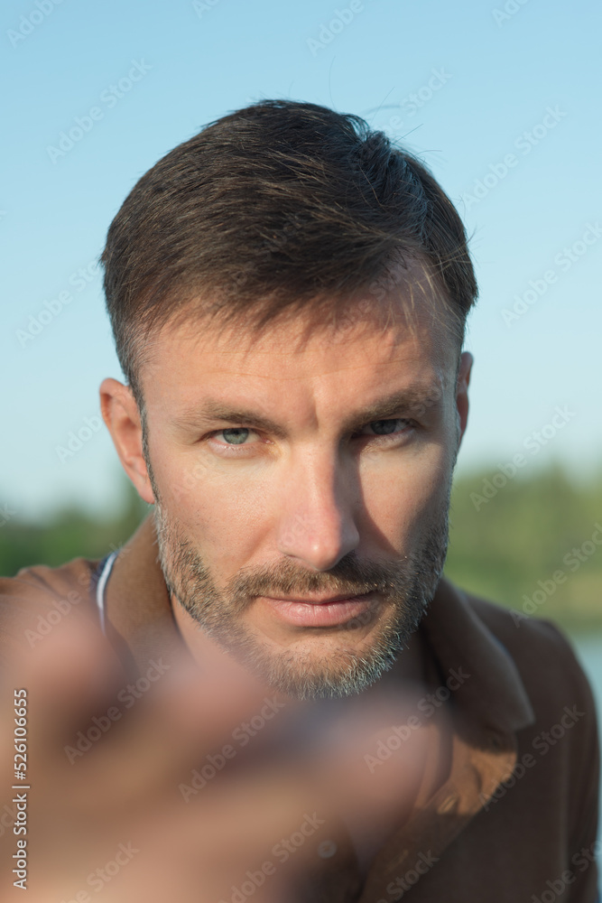 Fototapeta premium One man with a beard looks attentively into the camera, close-up.