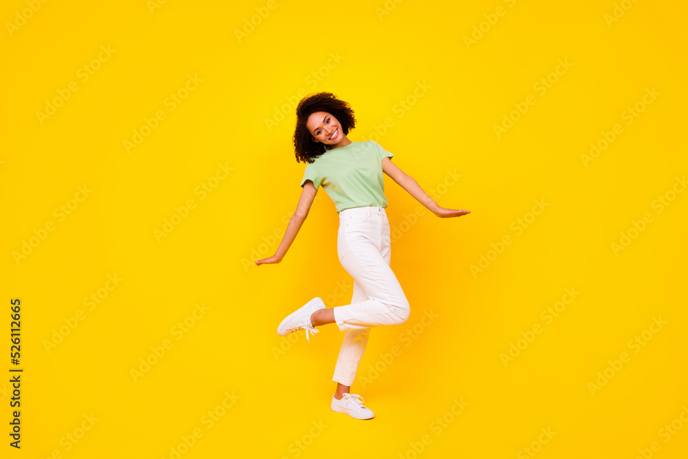 Full length photo of pretty sweet girl dressed green t-shirt dancing walking isolated yellow color background