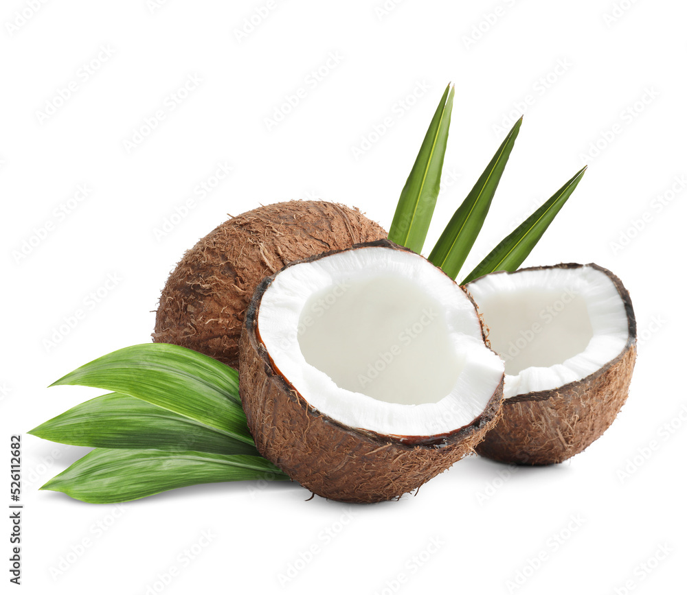Tasty ripe coconuts and green leaves on white background Tasty ripe coconuts and green leaves on white background
