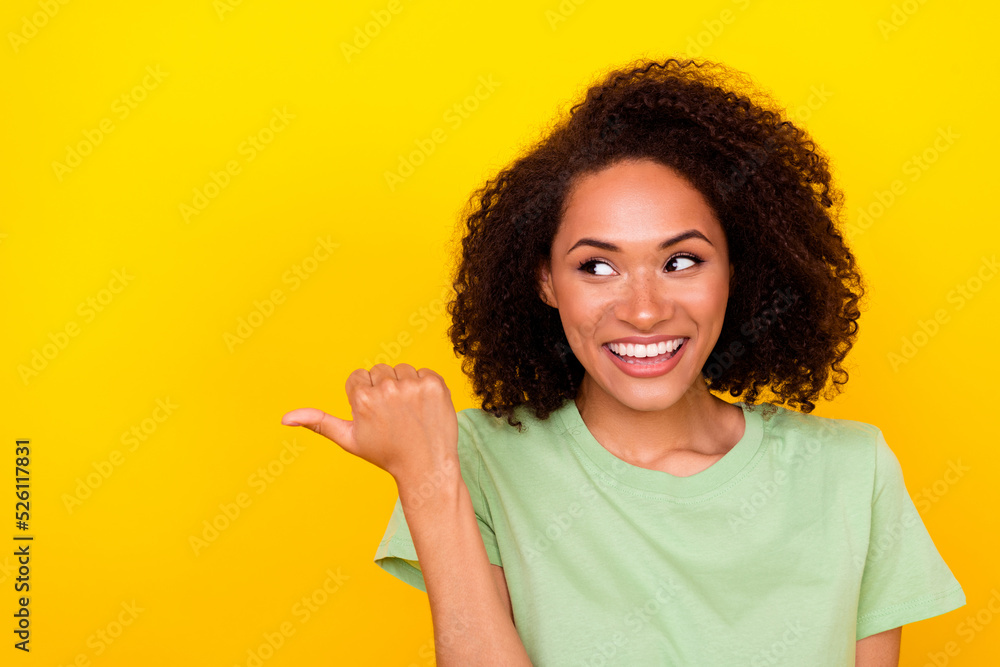 Photo of impressed brunette curly lady look promotion wear t-shirt isolated on bright yellow color background Photo of impressed brunette curly lady look promotion wear t-shirt isolated on bright yellow color background
