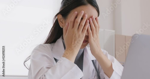 Young asia medical people sit work on desk at clinic office sad stiff neck stress tired long care online telehealth teleconsult telemedicine. Staff worker pain close face hands on eyes end finish job. photo