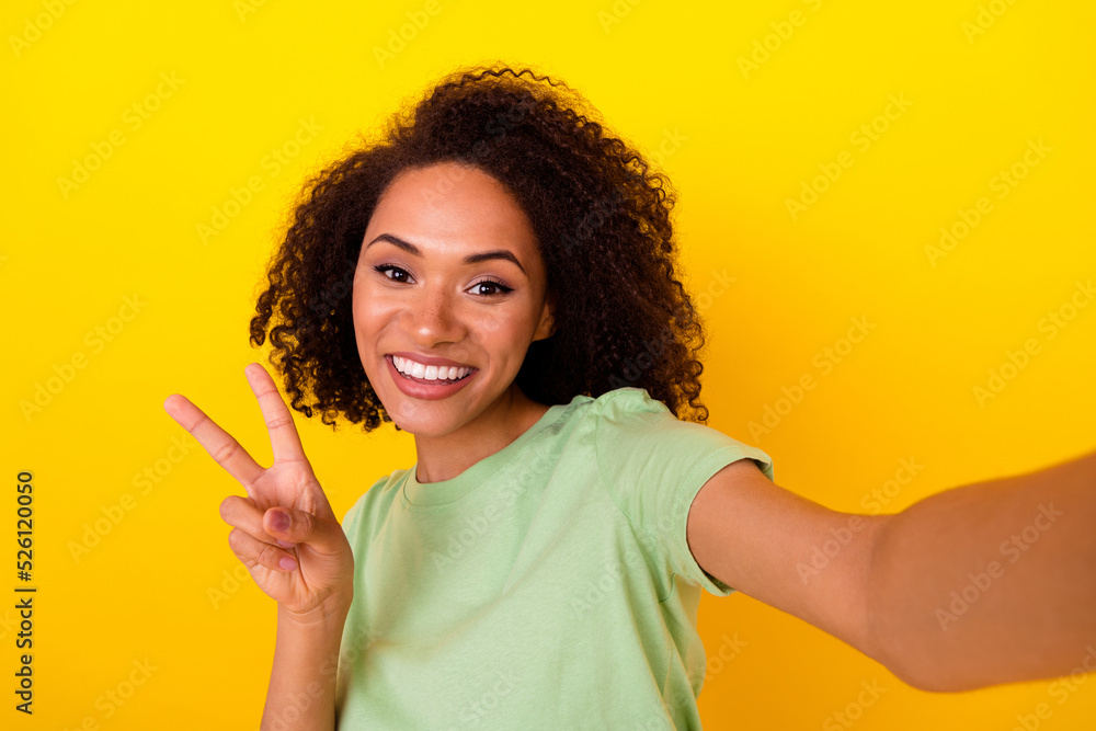 Photo of cheerful positive lady wear green t-shirt recording self video showing v-sign isolated yellow color background Photo of cheerful positive lady wear green t-shirt recording self video showing v-sign isolated yellow color background