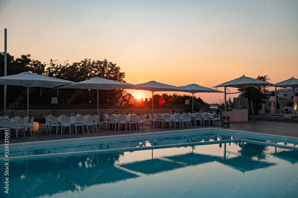 Blue swimming pool in a spa hotel in southern Italy at sunset.