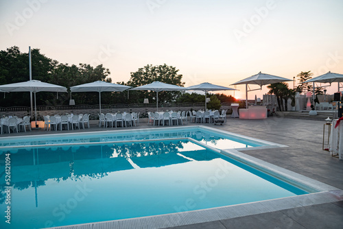 Blue swimming pool in a spa hotel in southern Italy at sunset. © Alona Dudaieva
