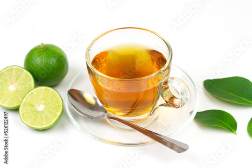 Hot tea in glass cup with fresh lime and green leaf isolated on white background.
