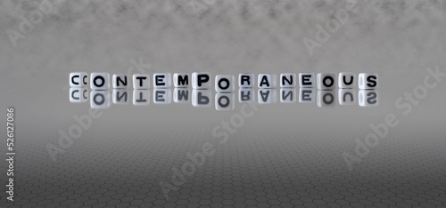 contemporaneous word or concept represented by black and white letter cubes on a grey horizon background stretching to infinity photo