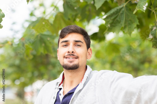 young man leaning arm to a tree in a city