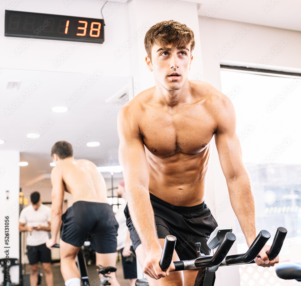 Young male athlete panting and exercising on bike Young male athlete panting and exercising on bike