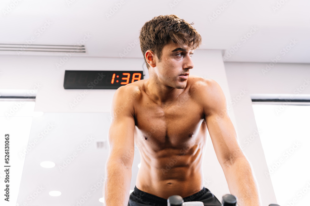 Obraz premium Sweaty sportsman exercising on bike and looking away