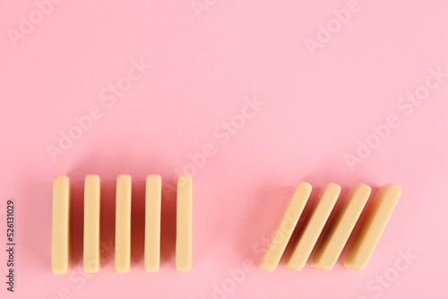 White domino tiles on pink background, flat lay. Space for text © New Africa