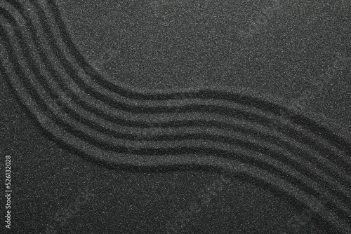 Black sand with beautiful pattern, top view. Zen concept photo