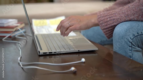The girl works with a laptop at home, looks at entries in her diary