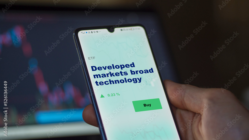 An investor's analyzing the DMEC etf fund on screen. A phone shows the ETF's prices developed markets broad technology An investor's analyzing the DMEC etf fund on screen. A phone shows the ETF's prices developed markets broad technology
