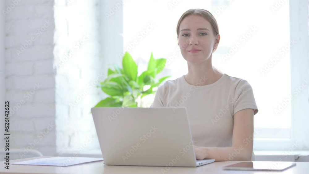 Woman Looking at Camera while using Laptop Woman Looking at Camera while using Laptop