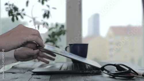 Close-up of hands closing the lid of the laptop and turning off the computer.