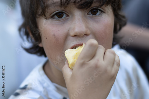 Brown-eyed cute boy eating an apple
