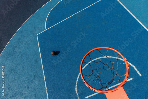 top view of basketball ring over ball on modern outdoor court © LIGHTFIELD STUDIOS