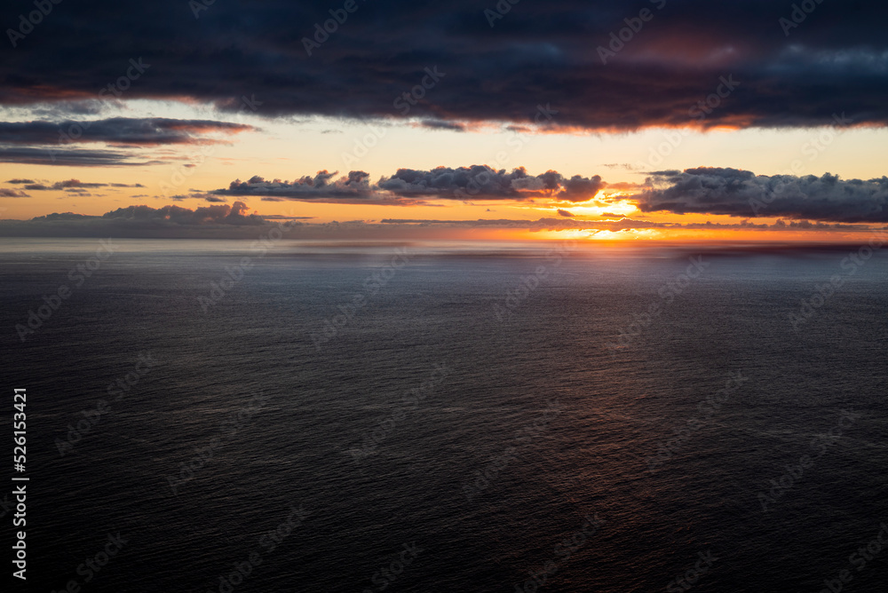 Picturesque seascape with illuminated clouds at sunset over the Atlantic Ocean at the west coast of Madeira, seen from Ponta do Pargo lighthouse