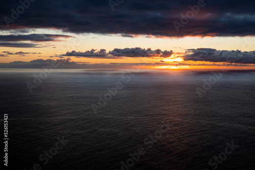 Picturesque seascape with illuminated clouds at sunset over the Atlantic Ocean at the west coast of Madeira, seen from Ponta do Pargo lighthouse photo