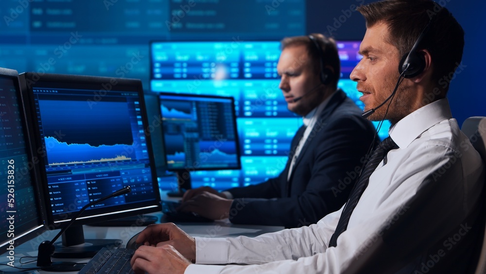 Team of brokers is working in office using workstation and analysis technology. Workplace of professional traders. Global financial markets, business strategy, currency exchange and banking. Team of brokers is working in office using workstation and analysis technology. Workplace of professional traders. Global financial markets, business strategy, currency exchange and banking.