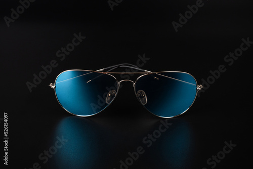blue polarized sunglasses closeup on dark background. photo