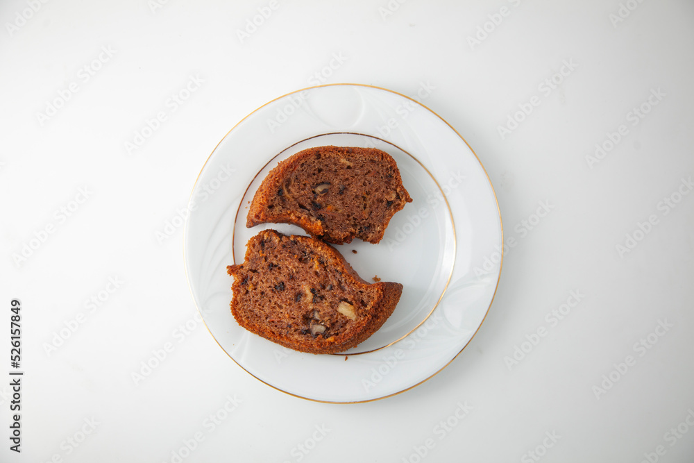 Two delicious slices of homemade carrot, hazelnut and cocoa cake on a gold plated porcelain plate. Snack. Two delicious slices of homemade carrot, hazelnut and cocoa cake on a gold plated porcelain plate. Snack.