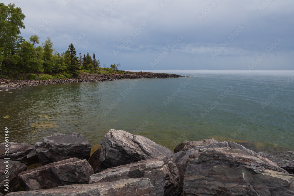 Coastline with tall trees and big rocks in foreground in Minnesota Coastline with tall trees and big rocks in foreground in Minnesota