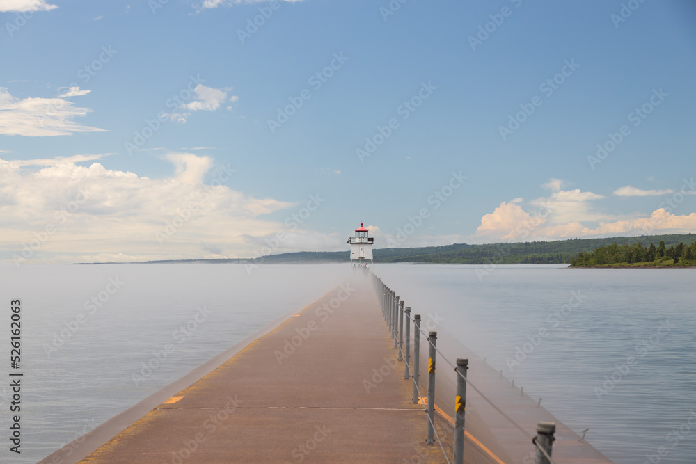 Obraz premium Two Harbors Light House in the fog at the end of the breakwater on Lake Superior, Michigan