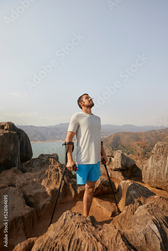 Disabled man standing on rock with crutches