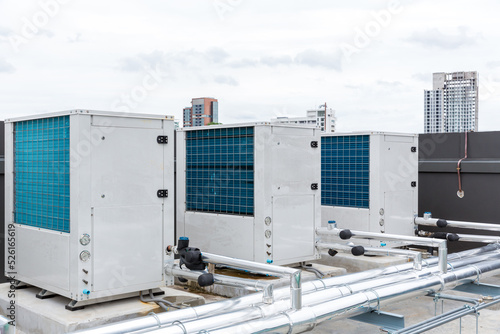 Air conditioner compressor installed on roof building. Industrial air conditioning units. Industrial air conditioning and ventilation systems on roof. Cooling towers in data center building. 